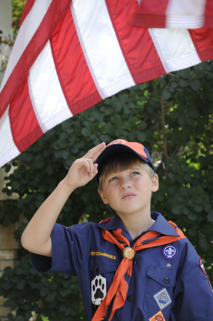 Tiger cub scout saluting the American flag